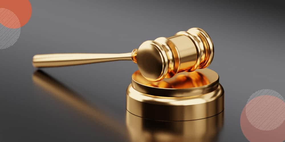 Martelo de juíz dourado sobre mesa de trabalho semi-espelhada