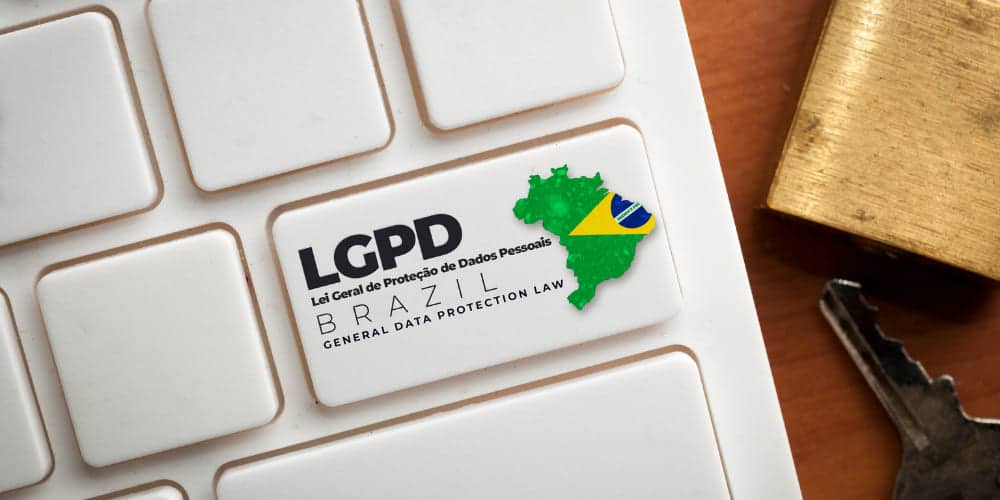 Tecla Enter de teclado de computador com a sigla LGPD, que indica a Lei Geral de Proteção de Dados, e um desenho do mapa do Brasil com as cores da bandeira