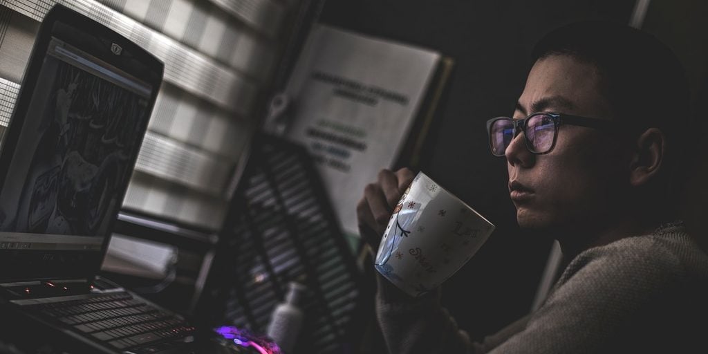 Homem trabalhando em frente a uma mesa em ambiente escuro