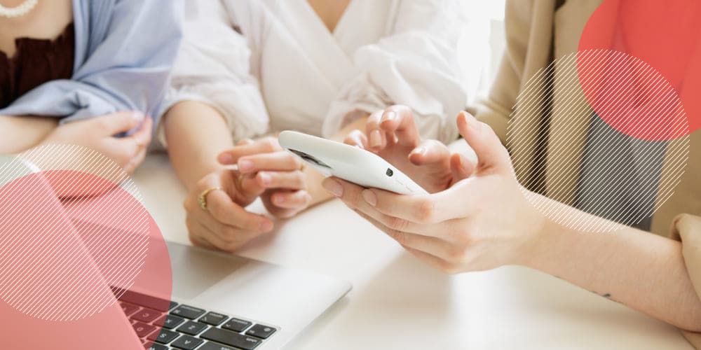 Colegas de trabalho mexendo em smartphone em mesa de escritório