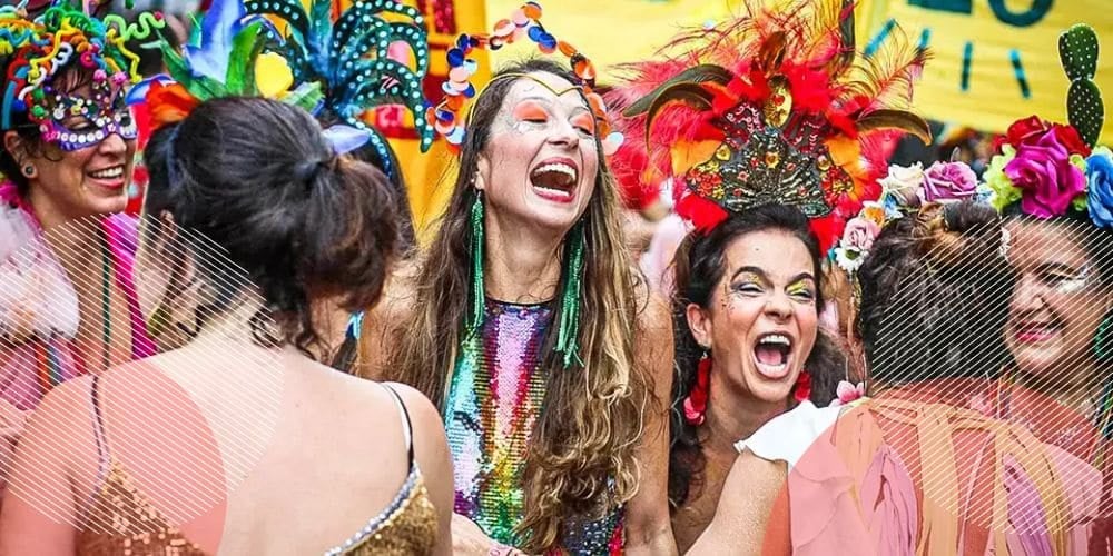 Mulheres sorridentes fantasiadas durante o carnaval de rua