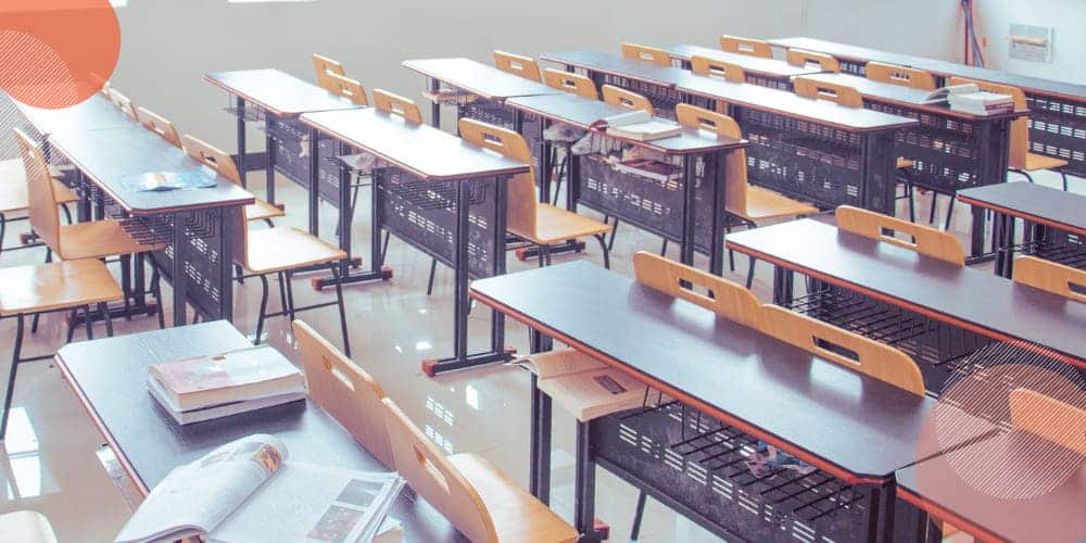 Sala de aula em escola com mesas e carteiras vazias