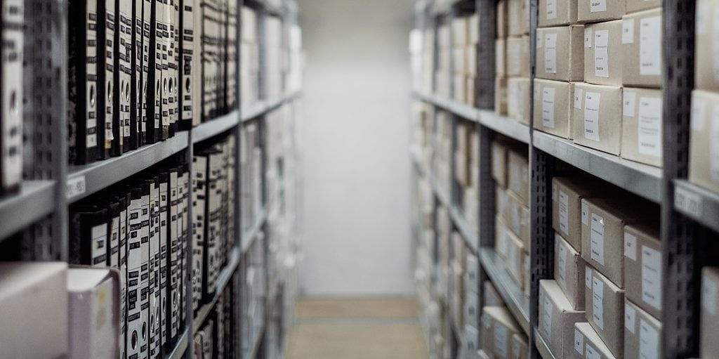 Corredor de biblioteca com livros e prateleiras cinzas