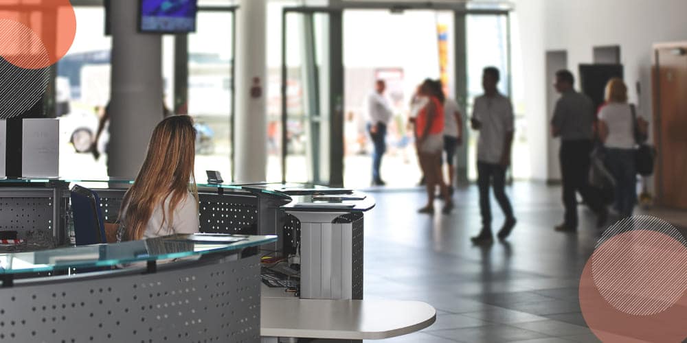 Mulher trabalhando como recepcionista em recepção de prédio comercial