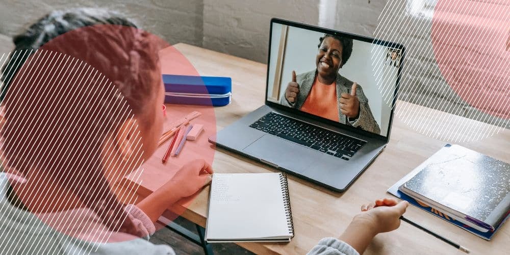 Trabalhadora falando com colega de trabalho via chamada de vídeo num computador apoiado sobre uma mesa de madeira, ilustrando como a gestão de pessoas remota é possível