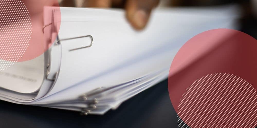 Pilha de documentos em papel sulfite branco presos por um grande clipe de papel