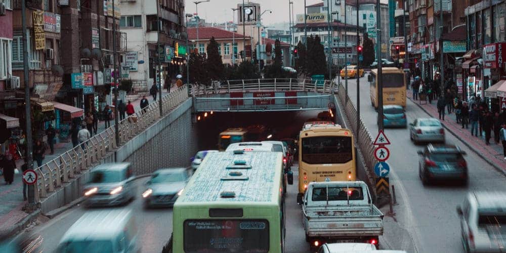Trânsito de carros, motos e ônibus em cidade grande