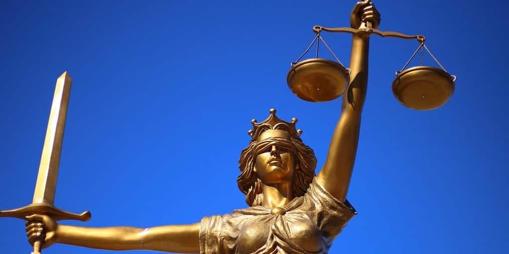 Estátua dourada representando a justiça, com olhos vendados e segurando uma balança