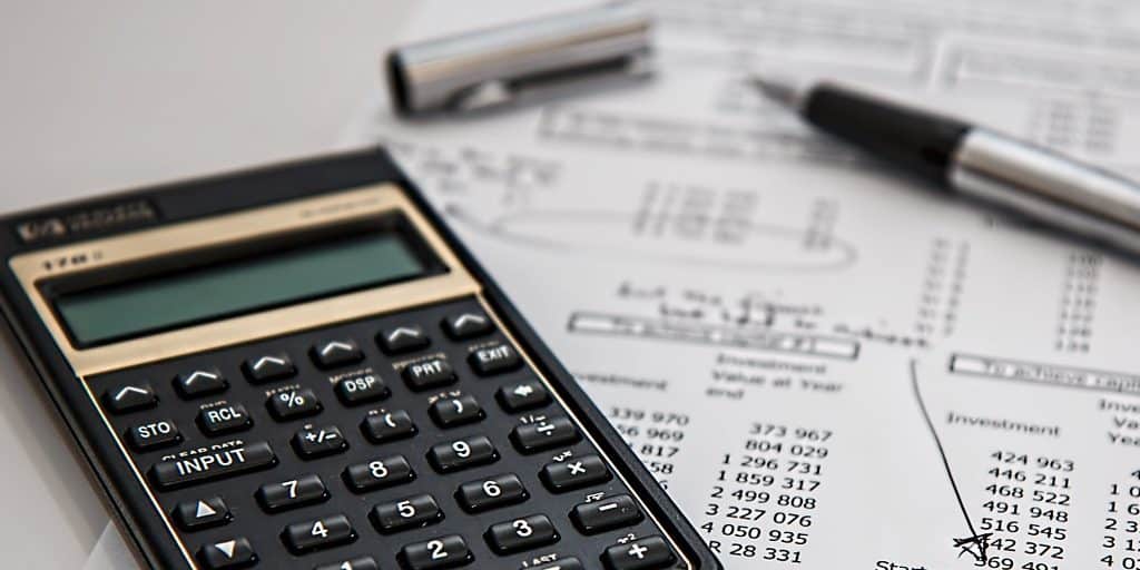 calculadora preta sobre documentos fiscais em mesa de escritório