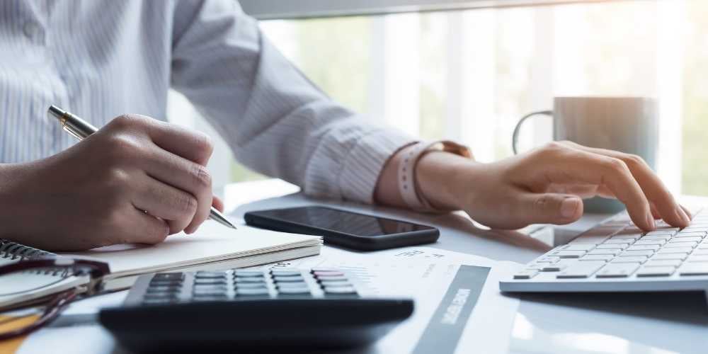Homem vestido com camisa social de mangas longas trabalhando em mesa de escritório