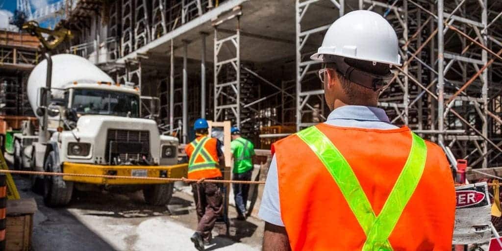 Trabalhadores em obra vestindo equipamentos de proteção individual