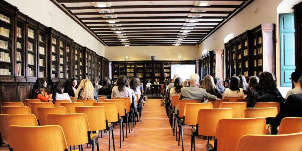 Sala de escritório com cadeiras laranjas organizadas em fileiras para treinamento na empresa