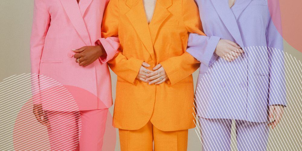 Pessoas com ternos coloridos de braços dados