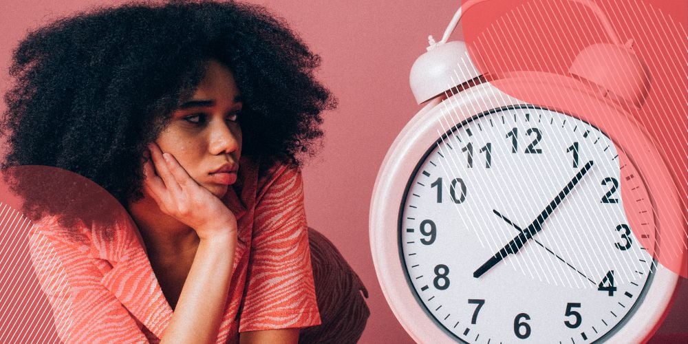 Menina com roupa cor de rosa observando relógio de ponteiros com olhar triste