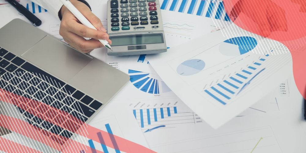 Planilhas financeiras e gráficos em azul sobre mesa de trabalho