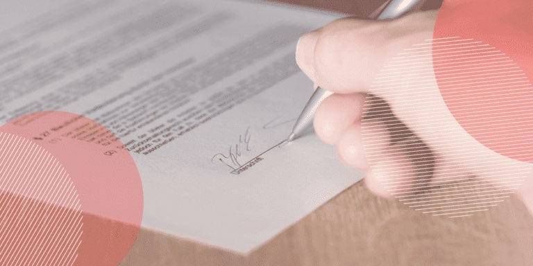 Pessoa assinando linha de documento com uma caneta prateada