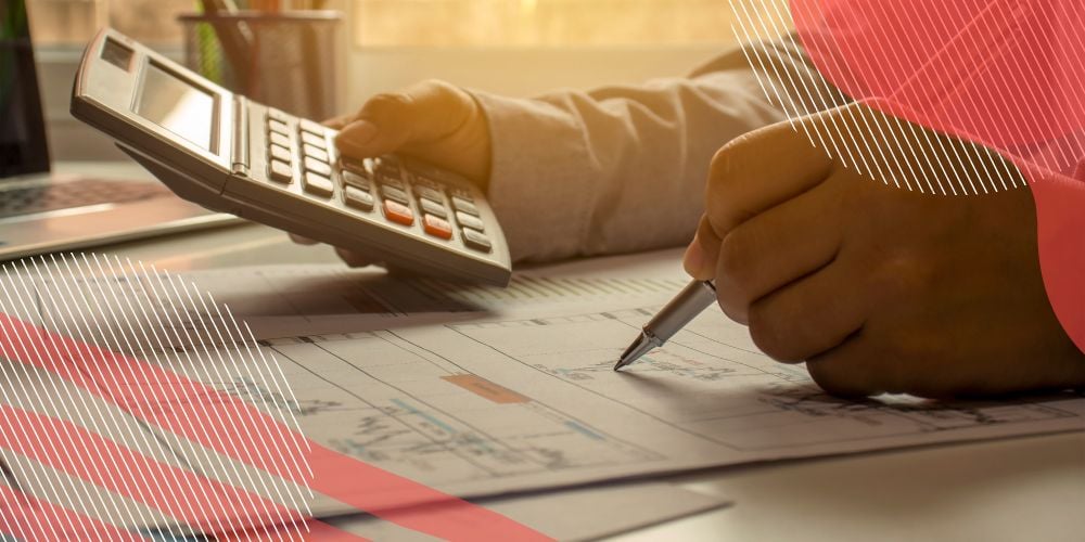 Contador fazendo gestão contábil empresarial em sua mesa com calculadora e caneta na mão