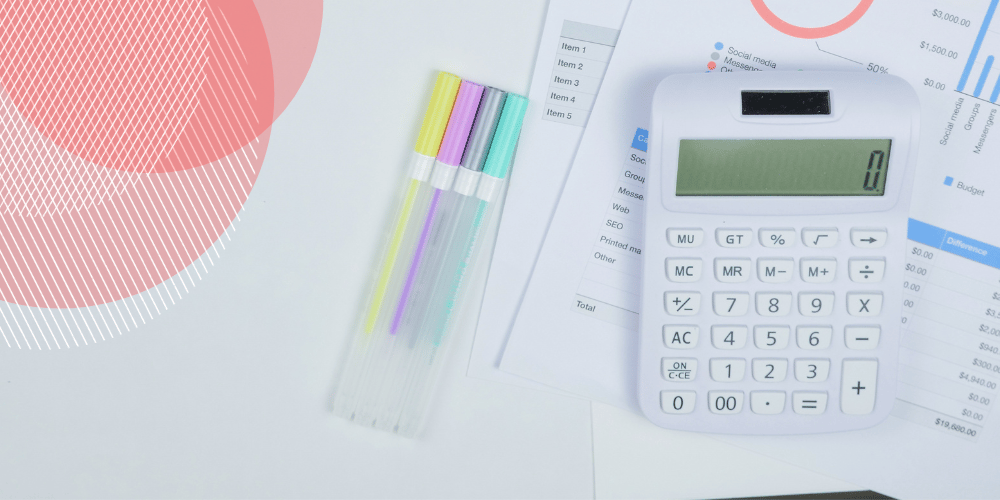 Calculadora, conjunto de canetas coloridas e documentos orçamentários sobre mesa branca