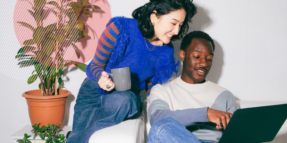 Homem e mulher conversando enquanto olham a tela de um computador