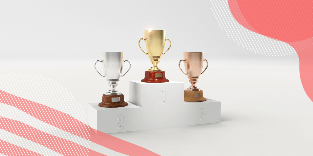 Pódio de premiação com troféus de ouro, prata e bronze sobre cada um dos níveis