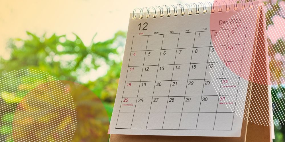 Calendário aberto na página de dezembro de 2022 sobre mesa de madeira