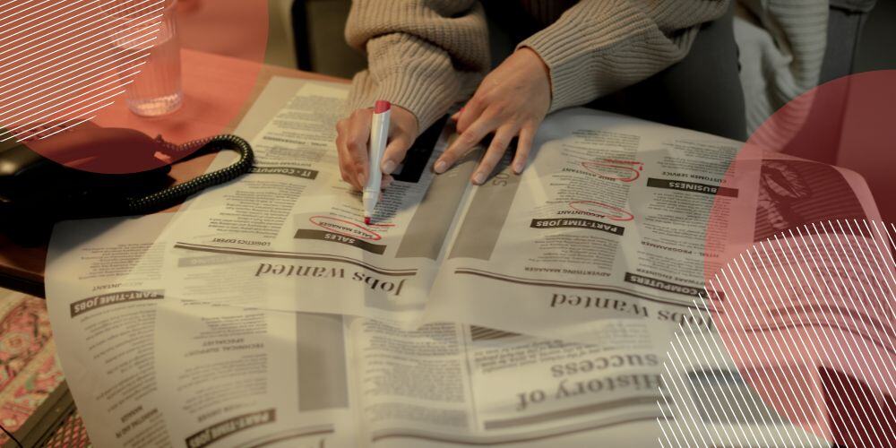 Pessoa circulando anúncios de emprego em jornal