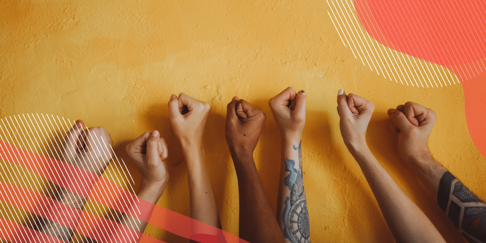 Mãos de pessoas de várias raças estendidas em punhos sobre fundo laranja